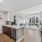 kitchen with stainless steel appliances and living area in the background
