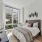bedroom with a night stands on each side of a bed and large windows