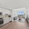 kitchen with stainless steel appliances and living area in the background