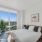 bedroom with large windows and a plant in the corner